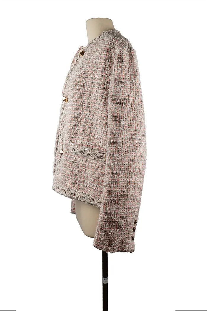 Profil gauche de la veste Valentino en tissu bouclé texturé, coupe élégante avec brillance discrète et détails Rockstud visibles de côté.